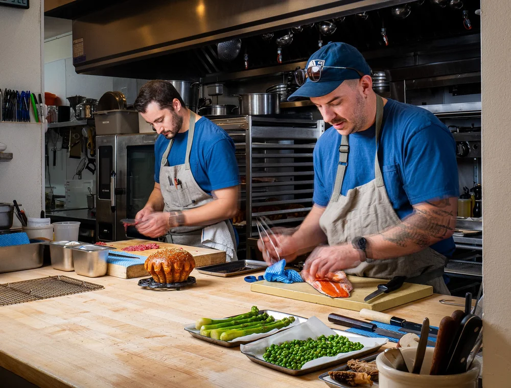 Chef Jacob Harth preparing dishes in the kitchen at Bistro Lagniappe